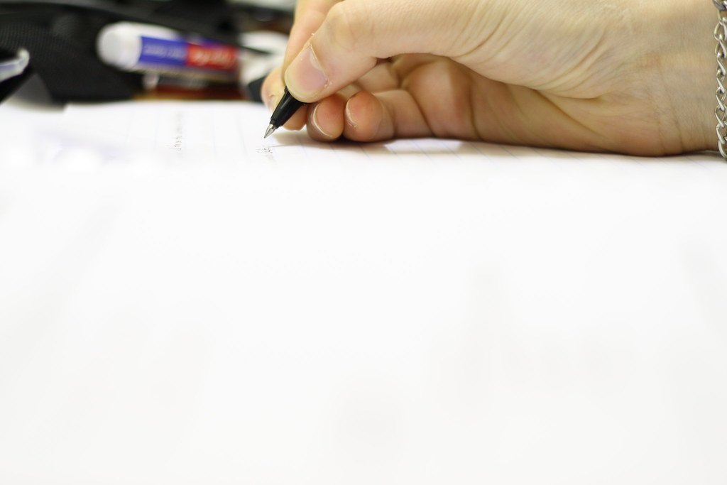 Main tenant un stylo sur un carnet